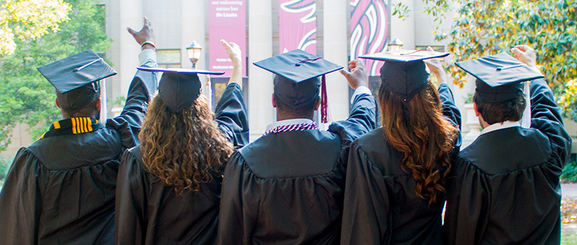 五名学生正对着麦基西克博物馆，头戴黑色帽子，身穿黑色长袍，右手举起，手指呈杯状，背诵着哈佛大学的母校